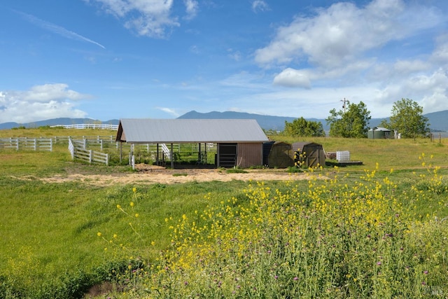 view of yard featuring a mountain view, an outdoor structure, and a rural view