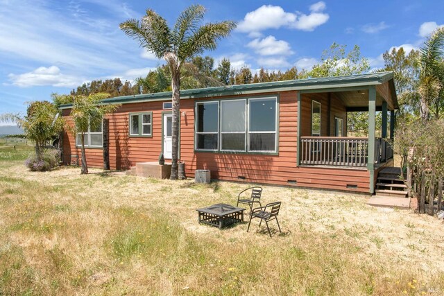 exterior space with a wooden deck and an outdoor fire pit