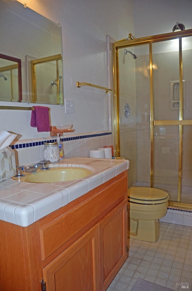 bathroom with tile flooring, an enclosed shower, tasteful backsplash, vanity, and toilet