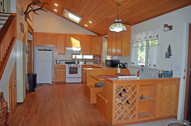 kitchen with kitchen peninsula, hardwood / wood-style floors, white appliances, hanging light fixtures, and high vaulted ceiling