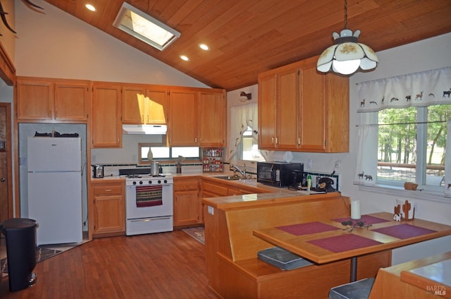 kitchen featuring white appliances, wood-type flooring, hanging light fixtures, sink, and a skylight