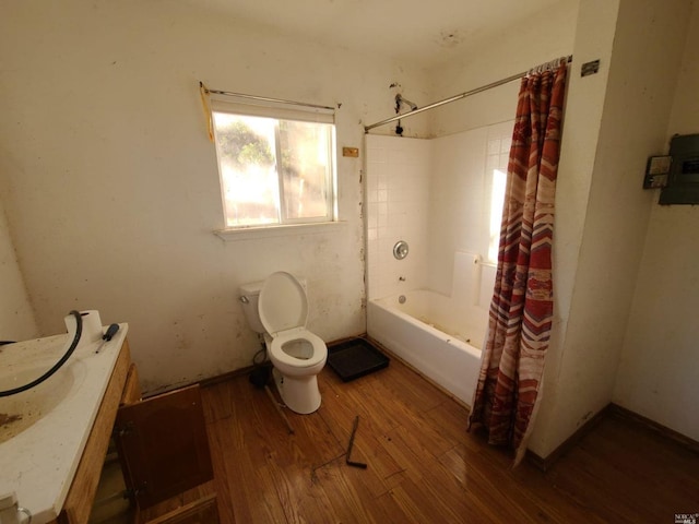 full bathroom featuring hardwood / wood-style floors, shower / bath combination with curtain, vanity, and toilet