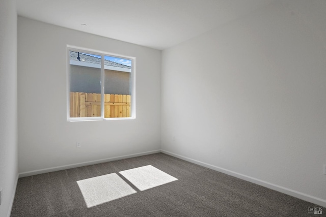 unfurnished room featuring dark colored carpet