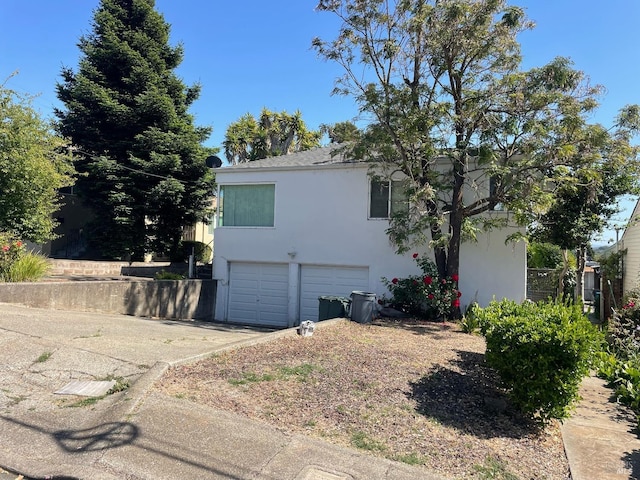 view of home's exterior featuring driveway, an attached garage, and stucco siding