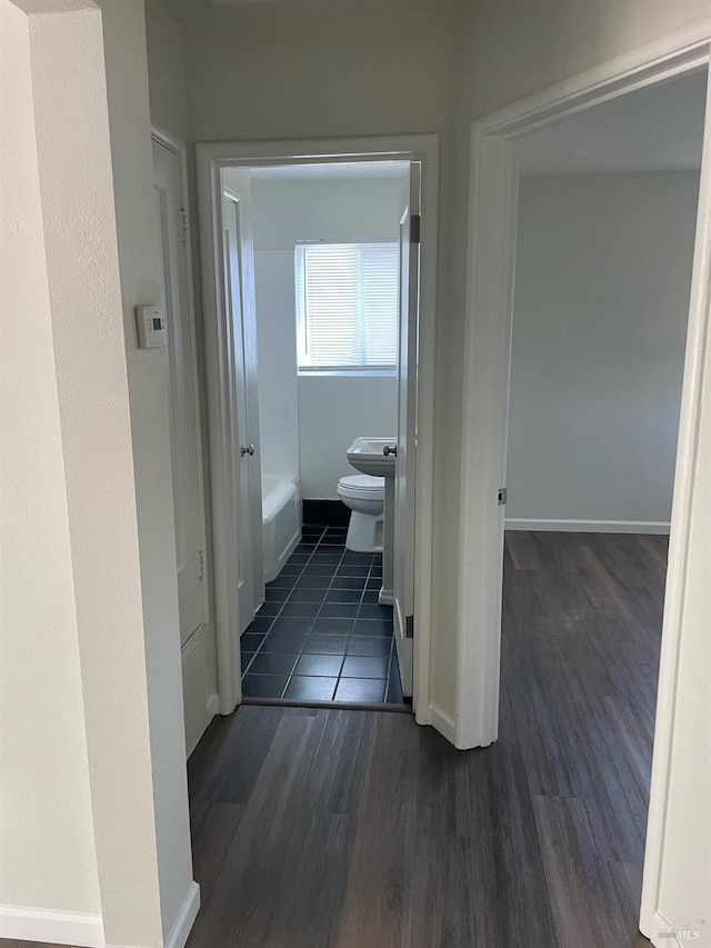 hallway with dark wood-style floors and baseboards
