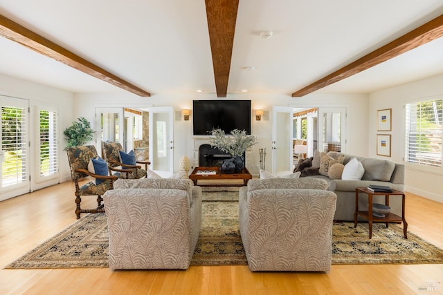 living room with light hardwood / wood-style flooring and beamed ceiling