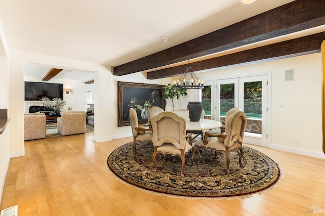 dining space with light hardwood / wood-style flooring and beamed ceiling