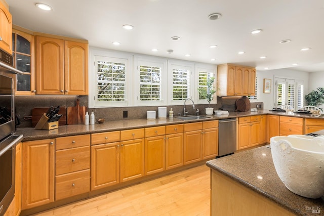 kitchen featuring sink, light hardwood / wood-style floors, a wealth of natural light, and appliances with stainless steel finishes