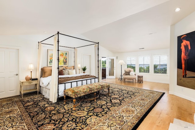 bedroom with wood-type flooring and vaulted ceiling