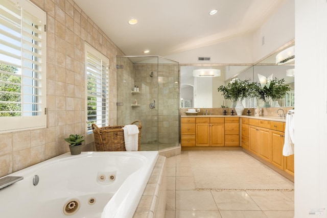 bathroom with tile patterned floors, vanity, tile walls, separate shower and tub, and lofted ceiling