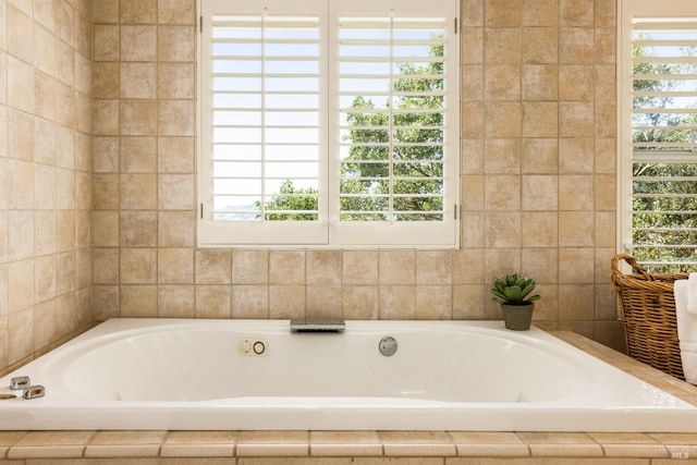 bathroom with a healthy amount of sunlight and tiled tub