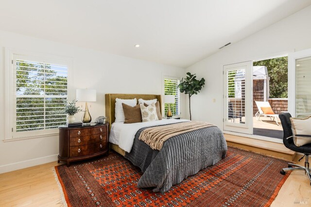 bedroom with access to outside, lofted ceiling, and wood-type flooring