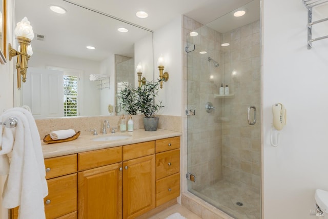 bathroom featuring a shower with door and vanity