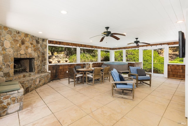 view of patio / terrace with a fireplace, a hot tub, and ceiling fan