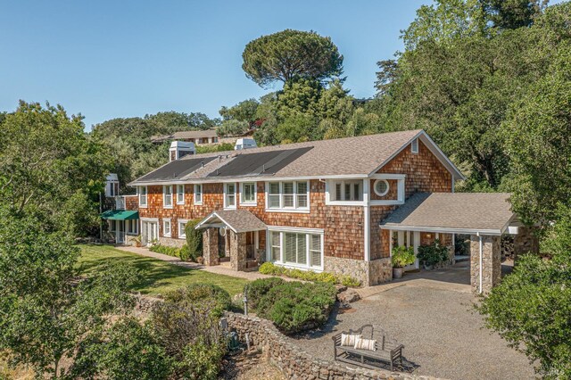 view of front of home featuring solar panels and a front lawn