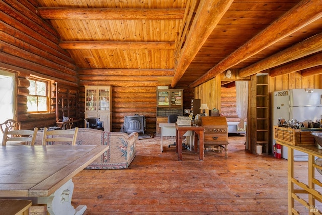 dining room featuring rustic walls, wood ceiling, lofted ceiling with beams, and a wood stove