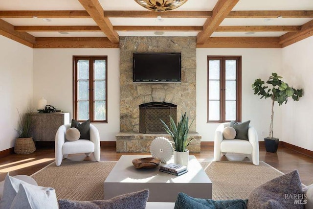 living room with a stone fireplace, beam ceiling, and plenty of natural light