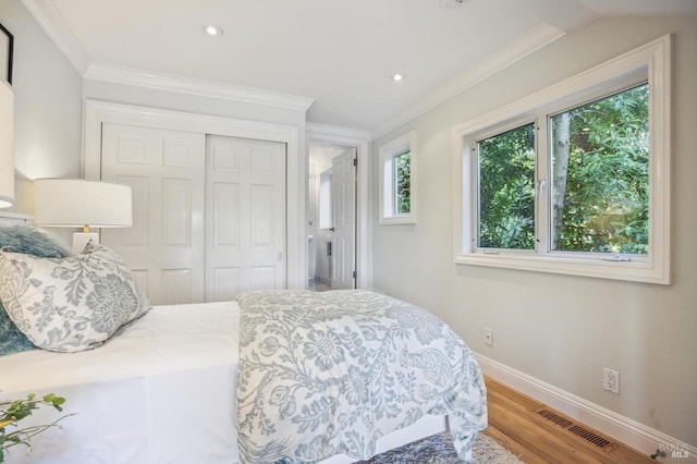 bedroom with ornamental molding, a closet, and wood-type flooring