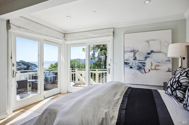 bedroom with ornamental molding, light wood-type flooring, and access to exterior