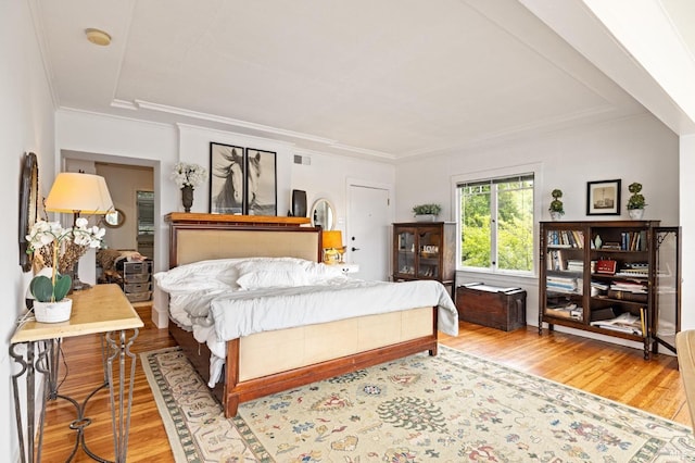 bedroom with ornamental molding and wood-type flooring