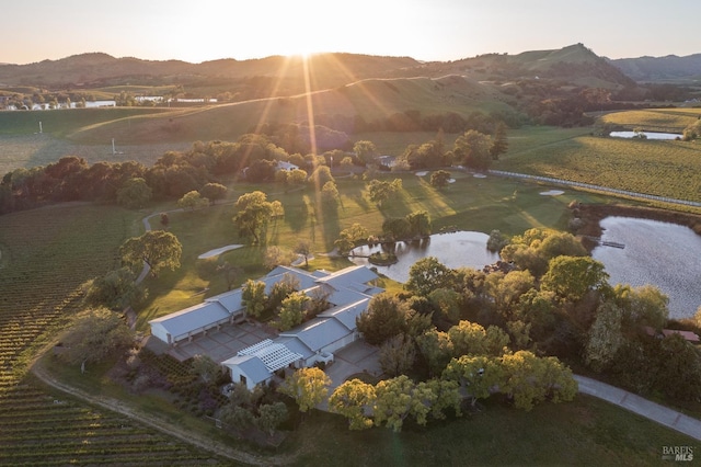 aerial view at dusk featuring a rural view and a water and mountain view