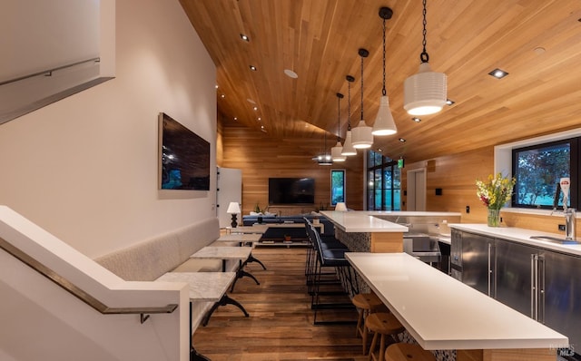 interior space with sink, wood walls, wooden ceiling, dark hardwood / wood-style floors, and pendant lighting