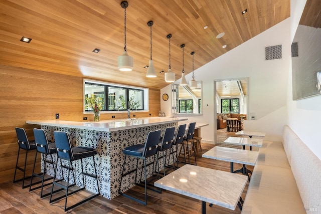 bar with lofted ceiling, hardwood / wood-style floors, wood ceiling, and decorative light fixtures