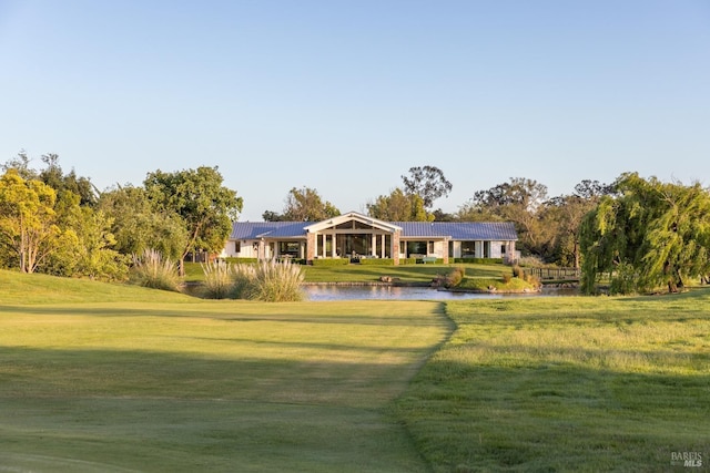 view of front of home with a water view and a front lawn