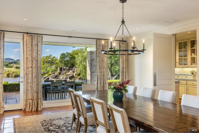 dining area featuring an inviting chandelier, ornamental molding, and light tile patterned flooring