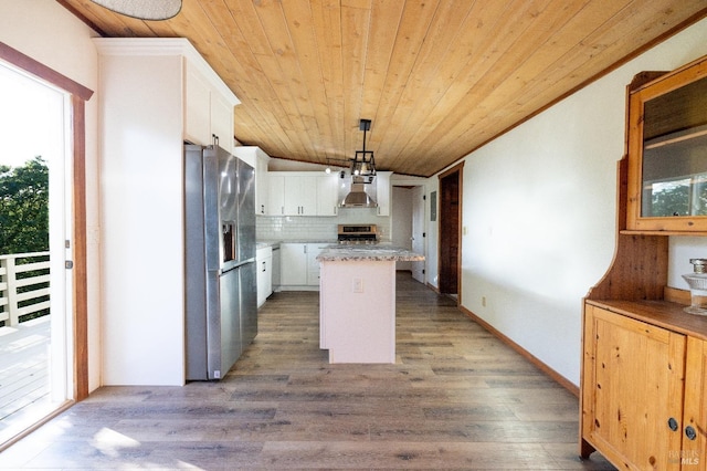 kitchen featuring stainless steel appliances, decorative backsplash, white cabinets, wall chimney exhaust hood, and a center island