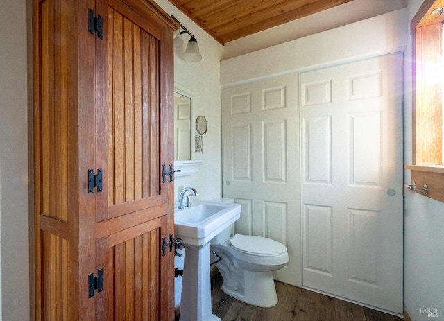 half bath with toilet and wood finished floors