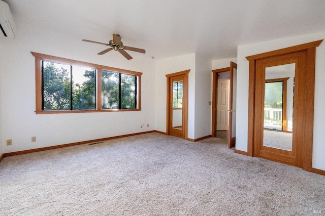 carpeted spare room with an AC wall unit, visible vents, baseboards, and ceiling fan