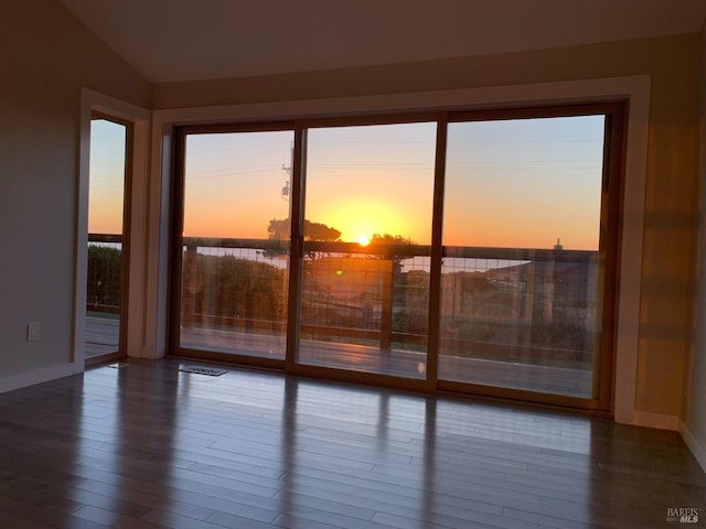 unfurnished room featuring hardwood / wood-style flooring and lofted ceiling