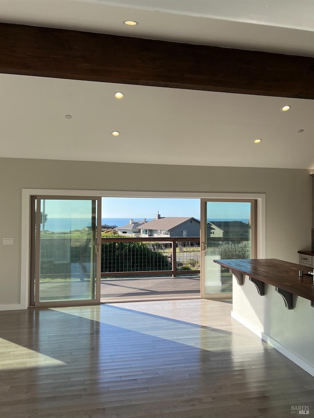 unfurnished room with beam ceiling and wood-type flooring