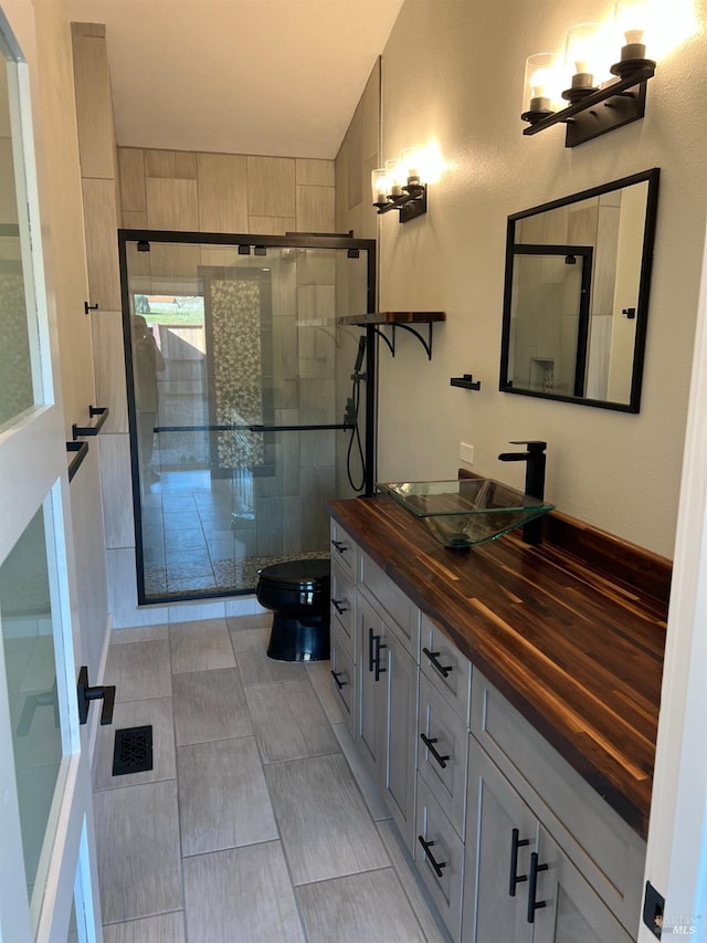 bathroom featuring tile flooring, vanity, and toilet