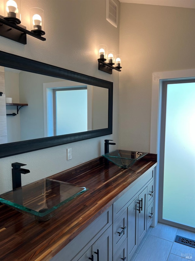 bathroom with a notable chandelier, tile flooring, and oversized vanity