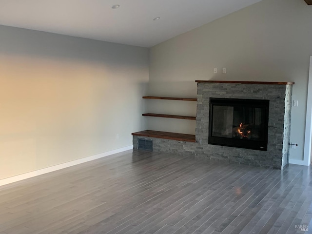 unfurnished living room with a stone fireplace and wood-type flooring