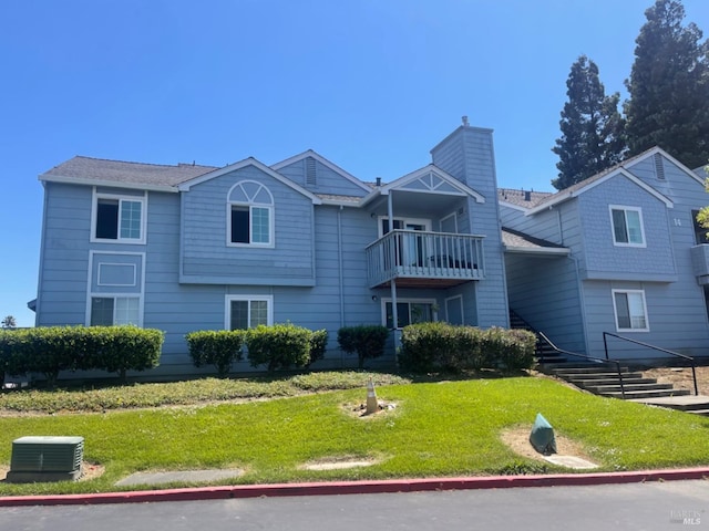 view of front of house with a front yard and a balcony