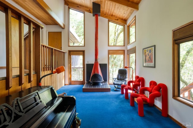 sitting room with wooden ceiling, a wood stove, high vaulted ceiling, carpet flooring, and beamed ceiling