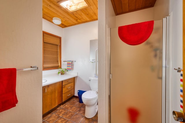 bathroom with a skylight, vanity, wooden ceiling, toilet, and a shower with shower door