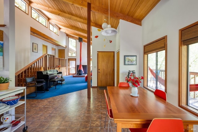 dining room with beam ceiling, a towering ceiling, and wooden ceiling