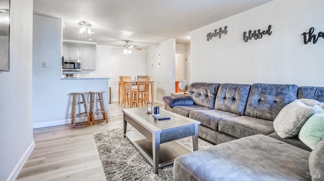 living room with light hardwood / wood-style floors and ceiling fan