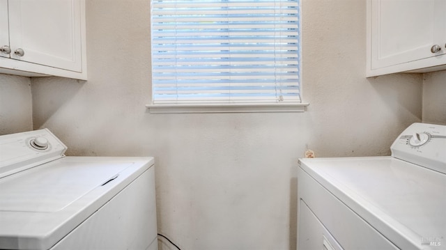 clothes washing area featuring cabinets and independent washer and dryer