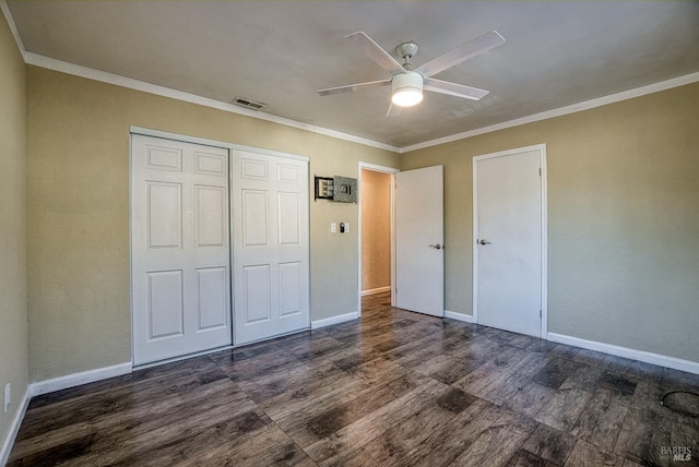 unfurnished bedroom with crown molding, ceiling fan, a closet, and dark hardwood / wood-style flooring