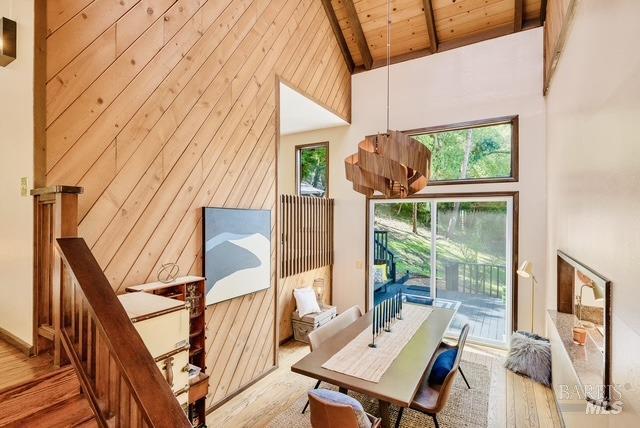 interior space featuring high vaulted ceiling, wood ceiling, wood finished floors, wood walls, and beamed ceiling