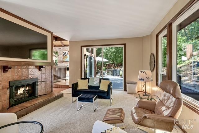 carpeted living room with a tiled fireplace