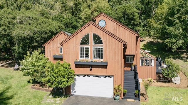 rustic home featuring stairs, driveway, and a garage