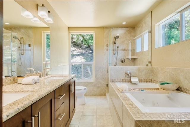 bathroom featuring tiled shower, a sink, a jetted tub, and toilet