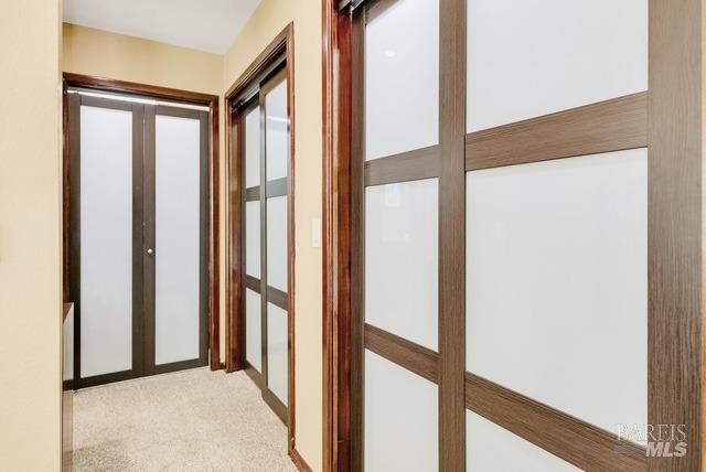 hall featuring french doors and light carpet