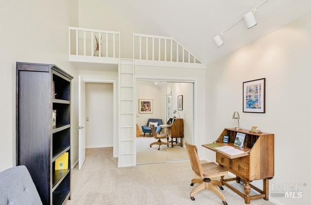 office with high vaulted ceiling, carpet flooring, and track lighting